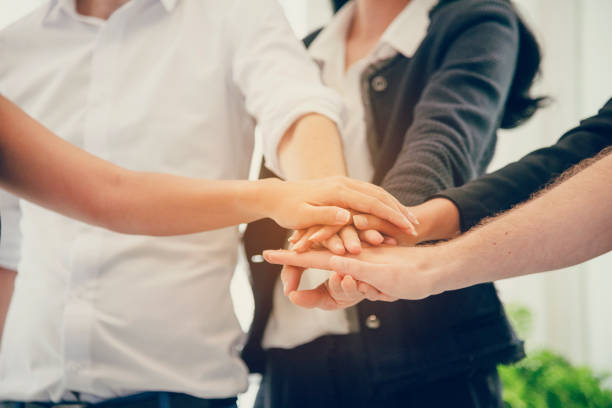 Verschillende handen op elkaar, als team, in zakelijke context